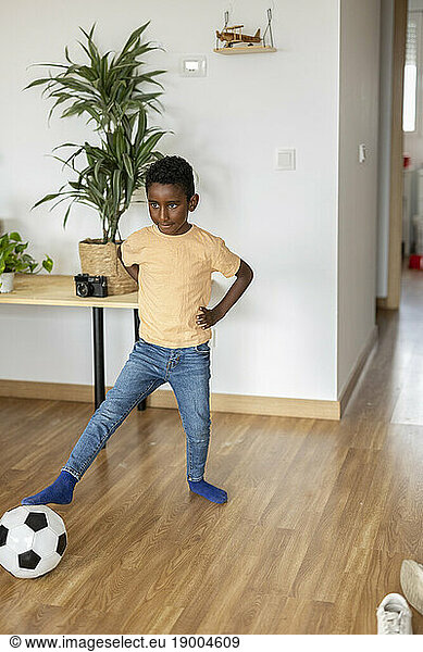 Boy playing with soccer ball at home