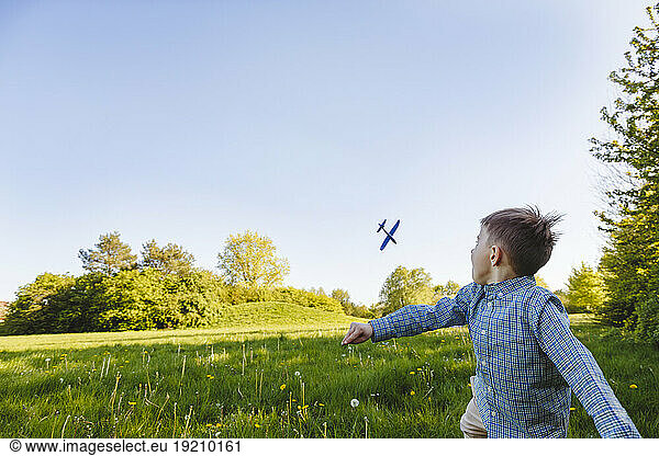 Boy playing with toy airplane in garden