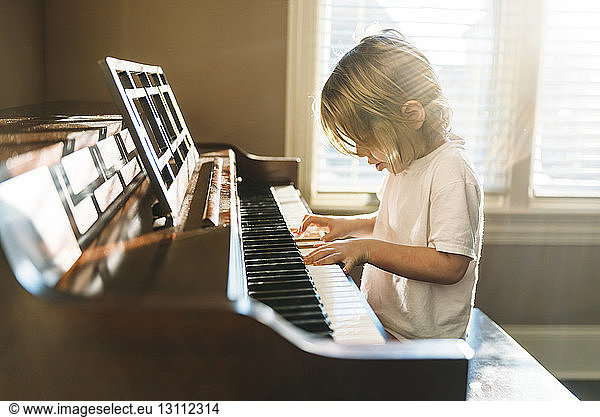 Boy practicing piano at home