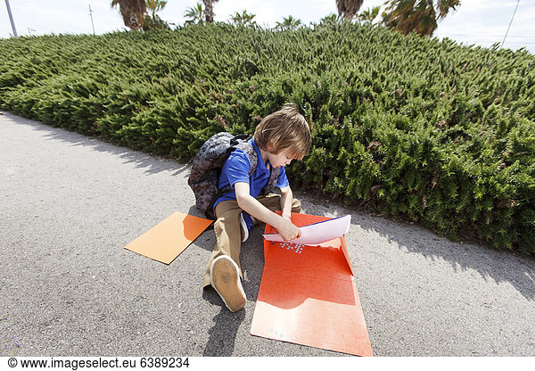 Boy pulling homework from folder