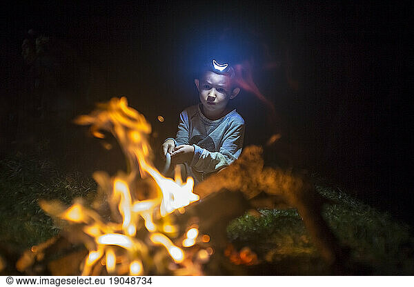 Boy roasting marshmallows in campfire