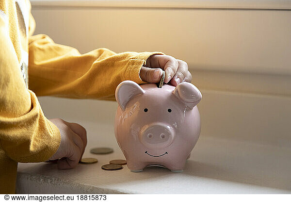 Boy saving money in piggy bank