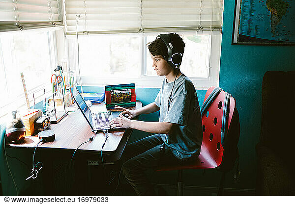 Boy Sits At Desk Attending His Zoom Class During Pandemic