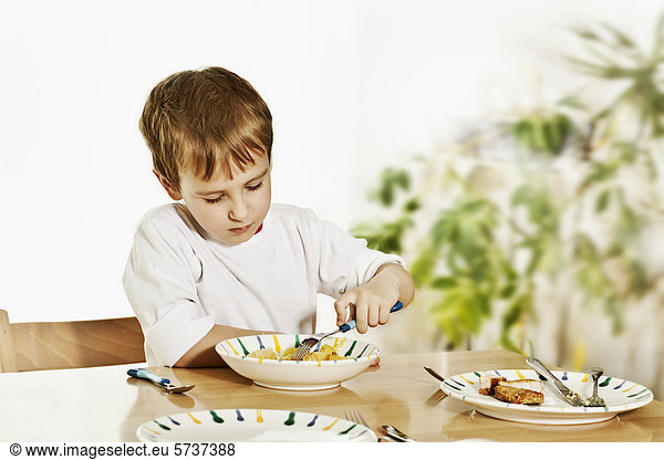 Boy  sitting at the dinner table  eating