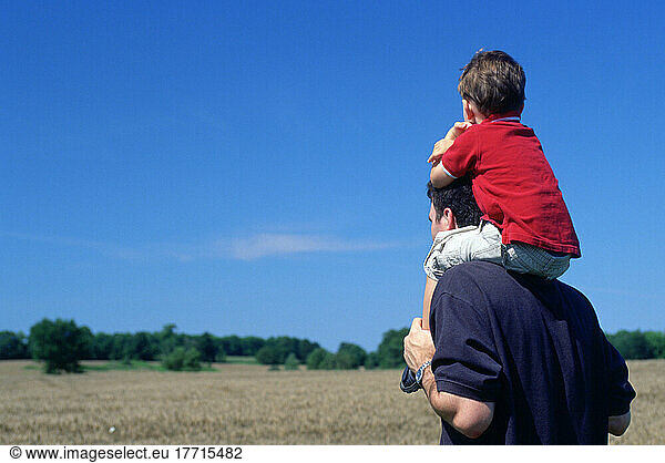 Boy Sitting On Father's Shoulders