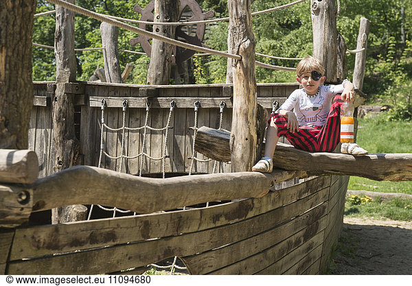 Boy sitting on pirate play ship in adventure playground  Bavaria  Germany