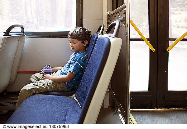 Boy sitting on seat while travelling in train