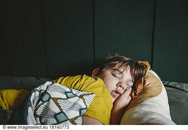 Boy sleeping in bed at home