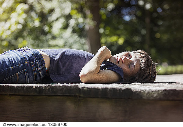Boy sleeping on porch in sunlight