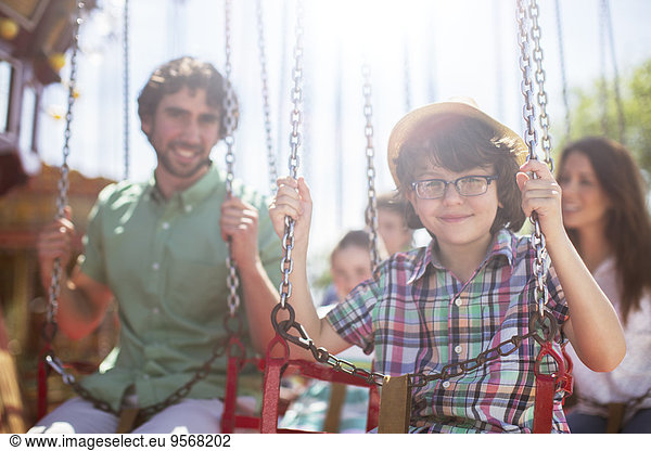 Boy smiling on carousel in amusement park