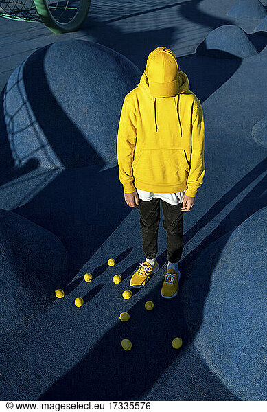 Boy standing amidst lemons at skateboard park