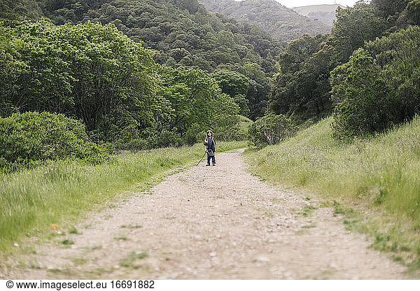 Boy standing by trail in natural park