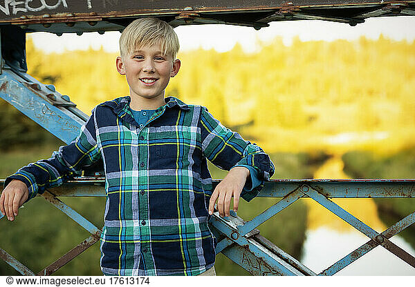 Boy standing outdoors on a park bridge looking at the camera; Edmonton  Alberta  Canada