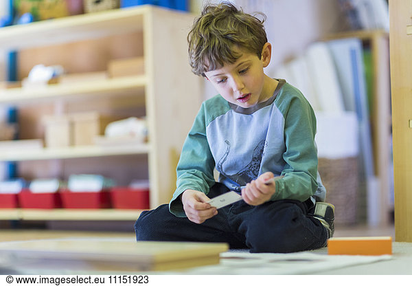 Boy thinking on floor in classroom