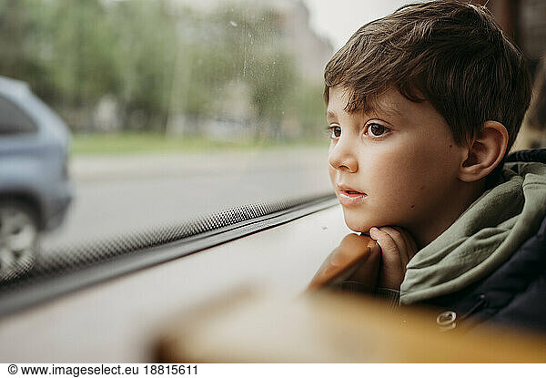 Boy traveling by tram sitting near window