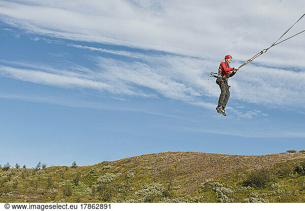 boy using a giant swing at high rope access course in Iceland