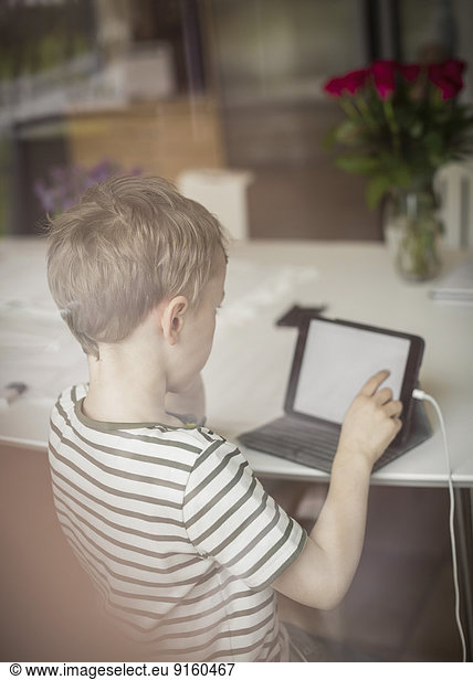 Boy using digital tablet at table