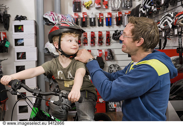 Boy with bicycle helmet in bike shop