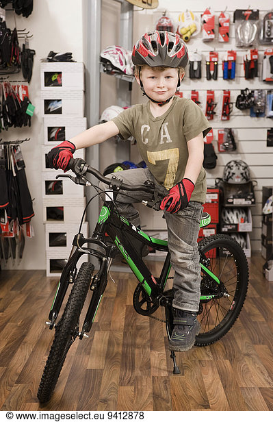 Boy with bicycle helmet in bike shop