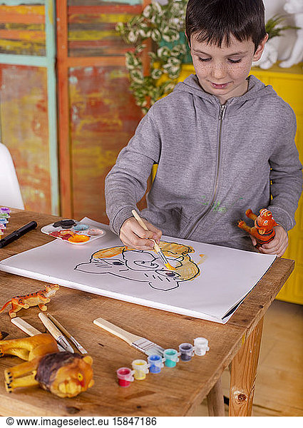 Boy with brush painting a tiger.