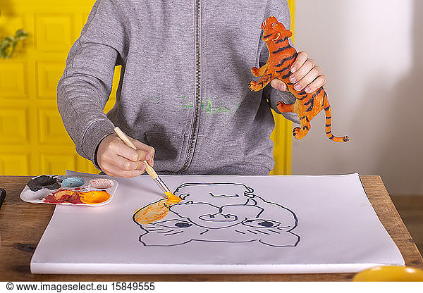 Boy with brush painting a tiger