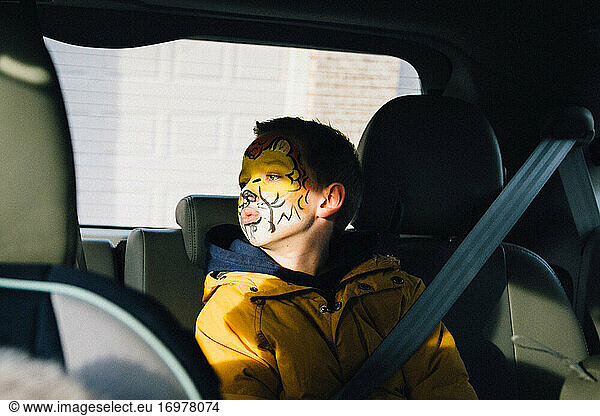 Boy with face paint looking to the window