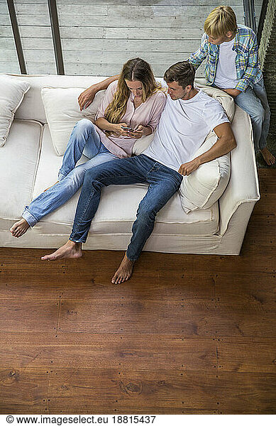 Boy with father and mother using smart phone at home
