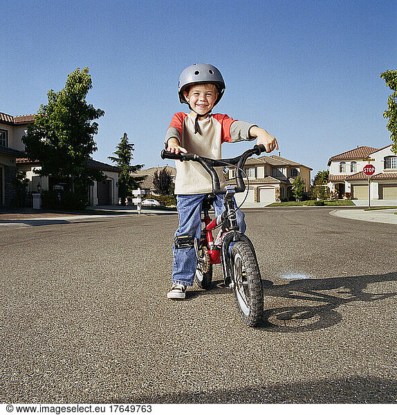Boy (6-7) with helmet riding bicycle