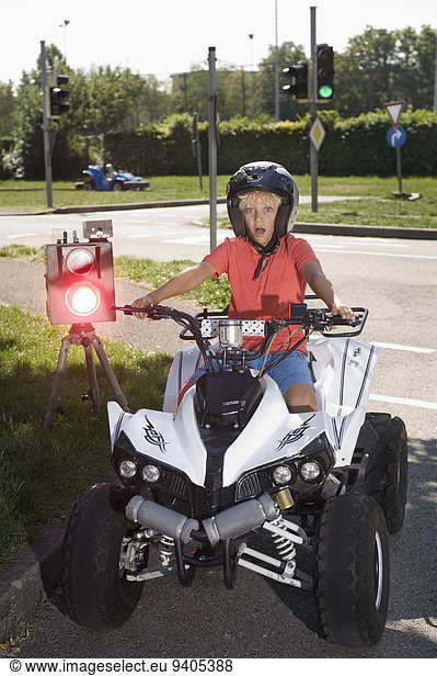 Boy with quadbike on driver training area with speed trap