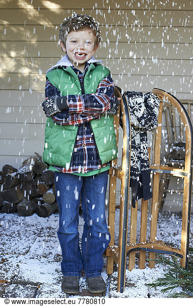 Boy with wooden sled in snow