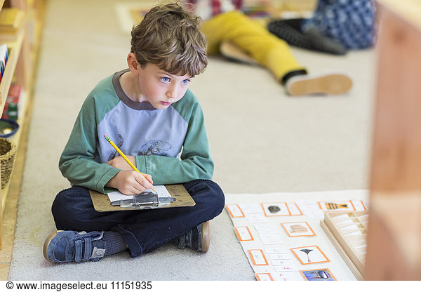 Boy writing in classroom