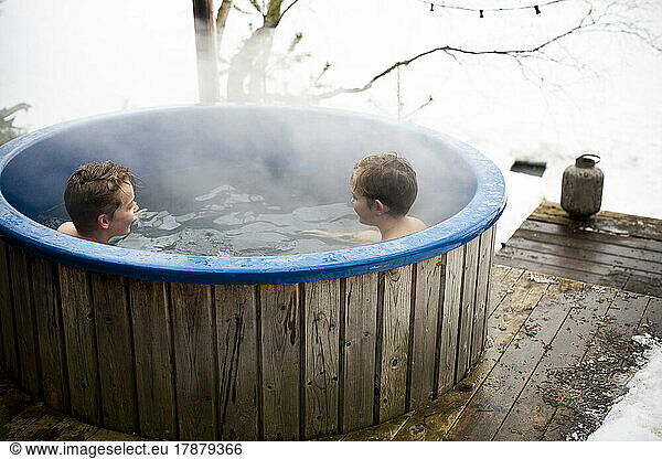 Boys enjoying in hot tub during winter