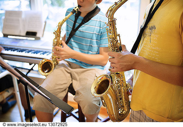 Boys practicing saxophones at home