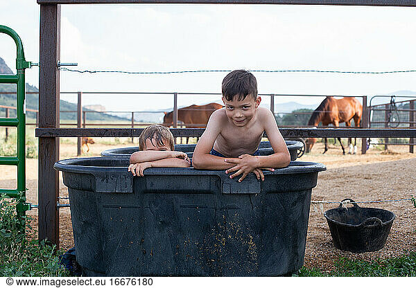 Boys sitting in horse trough