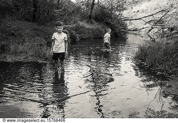Boys wading in river