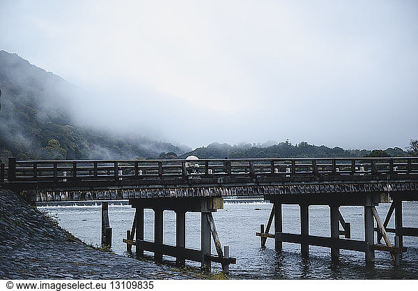Brücke über den Fluss bei Arashiyama bei nebligem Wetter