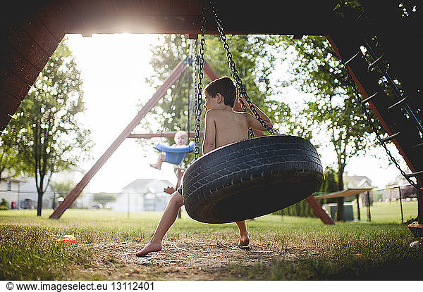 Brüder schaukeln auf dem Spielplatz
