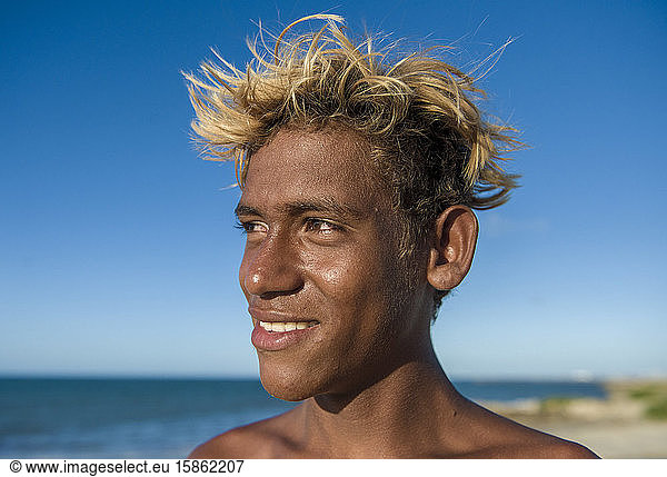 Brasilianischer Typ am Meeresufer mit gefärbten Haaren und brauner Haut