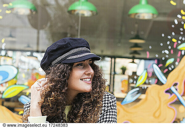Braunes lockiges Haar Frau schaut weg auf Bürgersteig Café