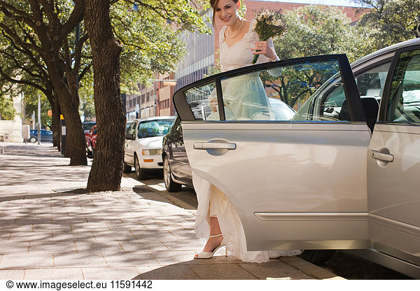 Braut  die vor der Hochzeit aus dem Auto steigt