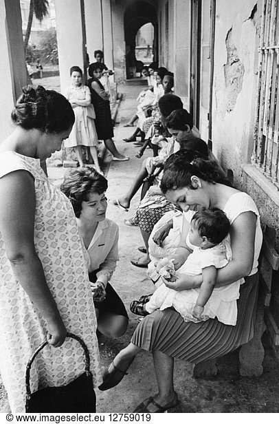 BRAZIL: CLINIC  c1964. Peace Corps volunteer social worker Linda Mathieson working with mothers and babies at a clinic in a suburb of Rio de Janeiro  Brazil. Photographed by Paul Conklin  c1964.
