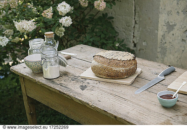 Bread with knife and sauce on table