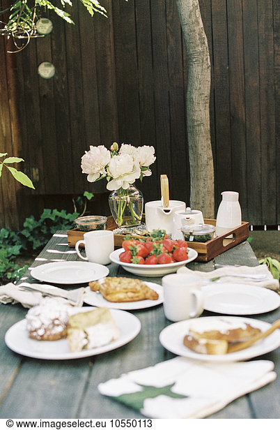 Breakfast table with tea  pastries and fresh strawberries.