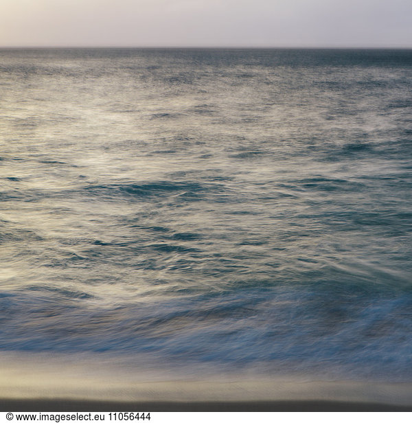 Breaking waves and the surface of the water at dawn.
