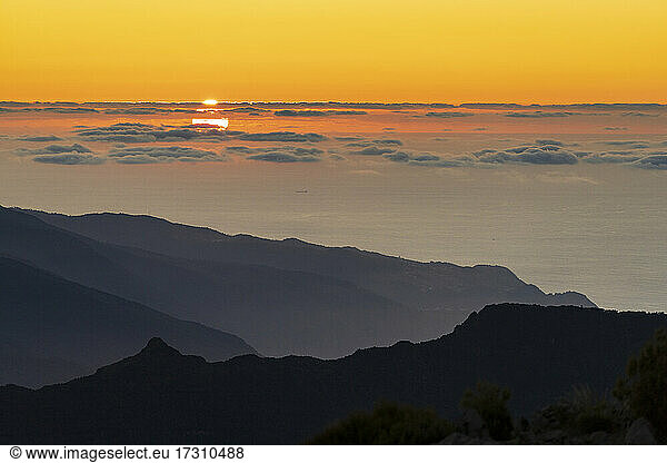Brennender Himmel bei Sonnenuntergang über dem Atlantischen Ozean und Silhouetten der Berge vom Gipfel des Pico Ruivo  Madeira  Portugal  Atlantik  Europa