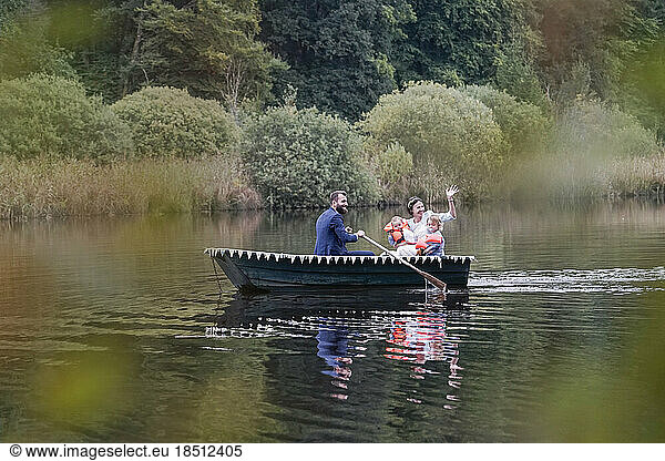 Bridal groom with children traveling in boat on lake  Bavaria  Germany