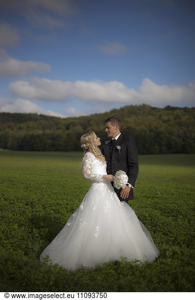 Bride and groom doing romance in field