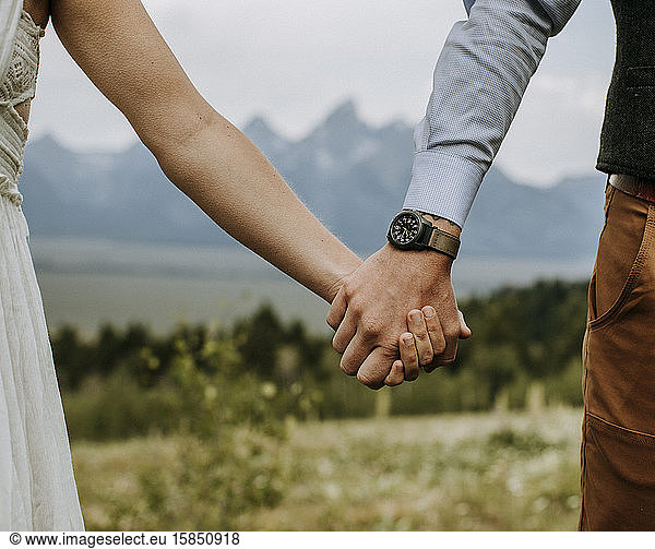 Bride and Groom hold hands in front of Grand Teton  Wyoming