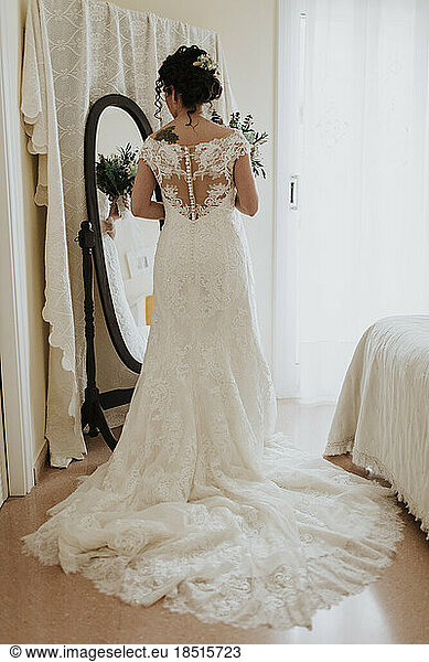 Bride in wedding dress looking in mirror