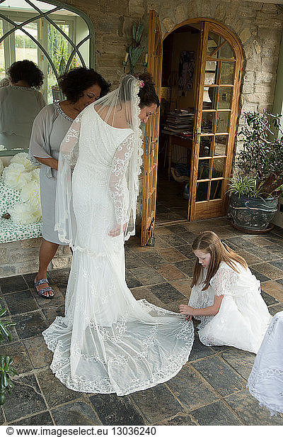 Bride's wedding dress being arranged